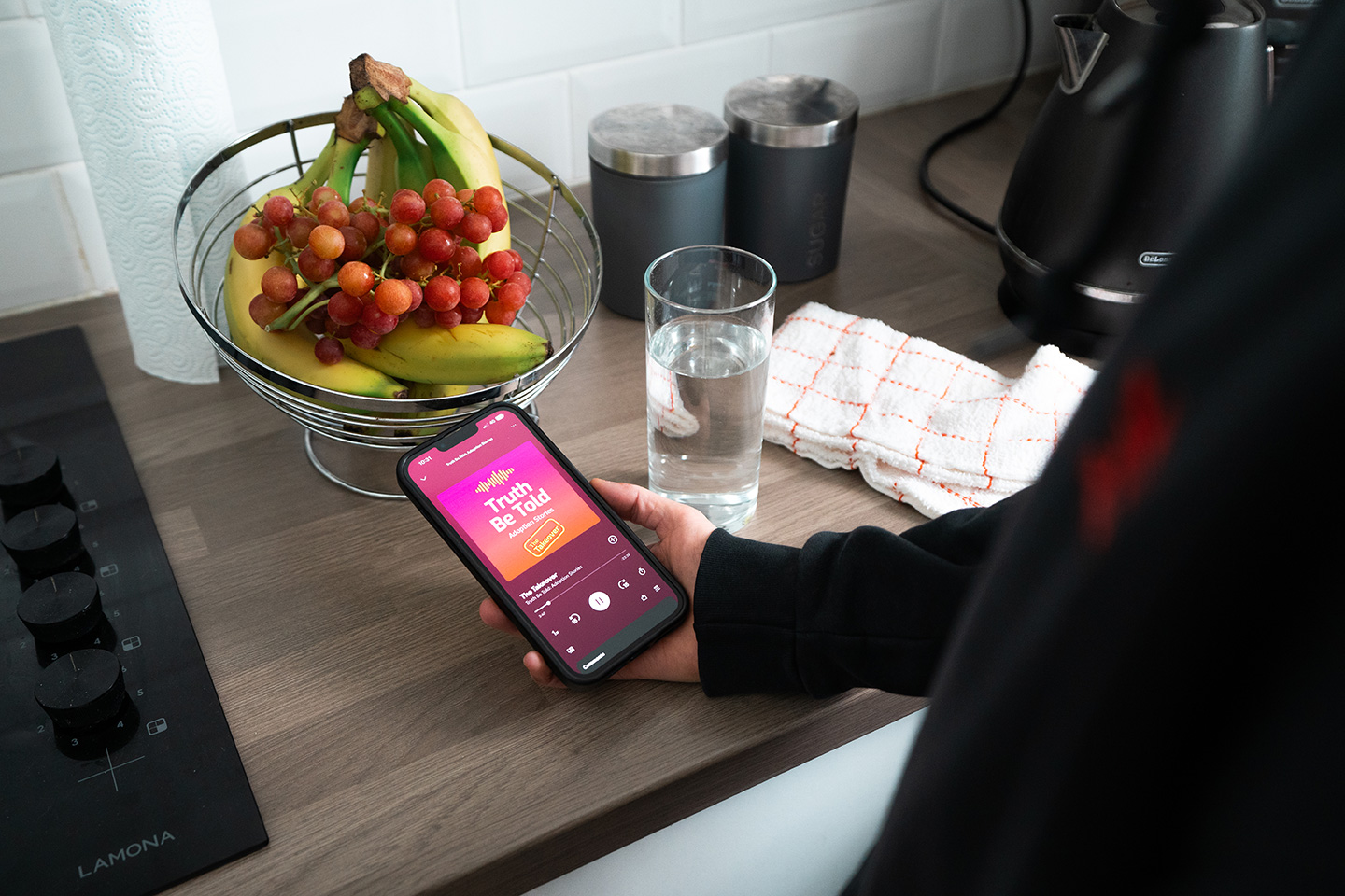 A phone in a kitchen with a podcast on the screen